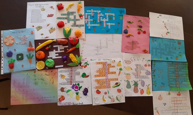 Na zdjęciu umieszczone są odręcznie wykonane kolorowe prace uczniów klas I-III przedstawiające obrazkową krzyżówkę z owocami i warzywami.