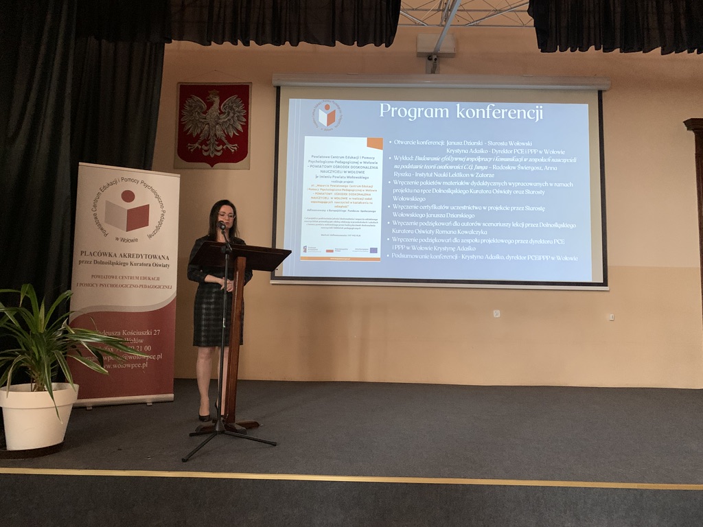 Na zdjęciu prowadząca konferencję specjalista ds. koordynacji i organizacji szkoleń PCEiPPP w Wołowie – lider projektu na tle slajdu pt. Program konferencji