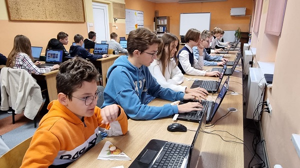 Na zdjęciu uczniowie, którzy pracują na komputerach. 