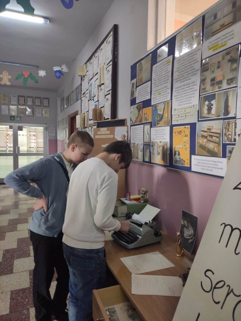Dwaj chłopcy stoją przy biurku, patrzą na eksponaty