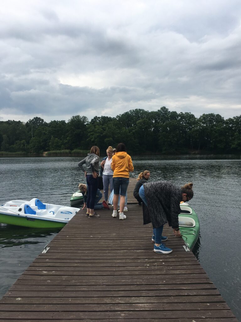 Grupa kobiet na pomoście na tle jeziora.