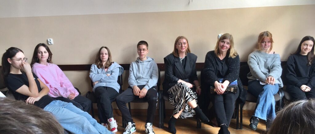 Aula szkolna, na środku uczniowie z nauczycielami