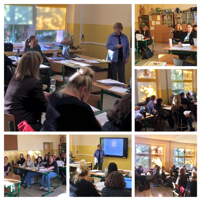 Klasa, w której przy stolikach siedzą nauczyciele. Na stolikach leżą kartki, notatniki. Kobieta prowadzi spotkanie. 

