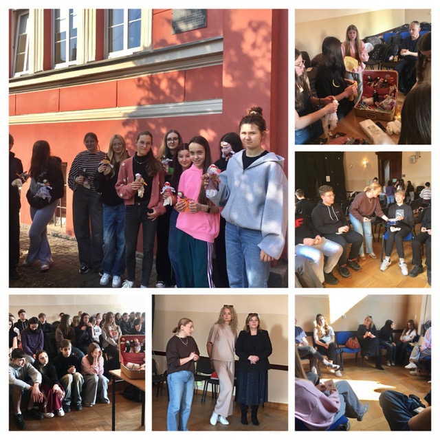 Aula szkolna, na środku uczniowie z nauczycielami. 