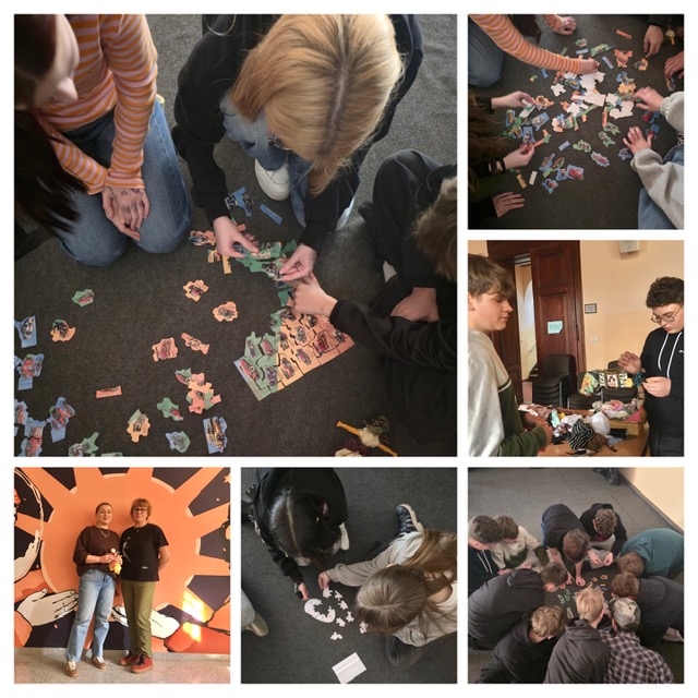 Aula szkolna, na środku sceny uczniowie coś układają. Na podłodze leżą kartki.