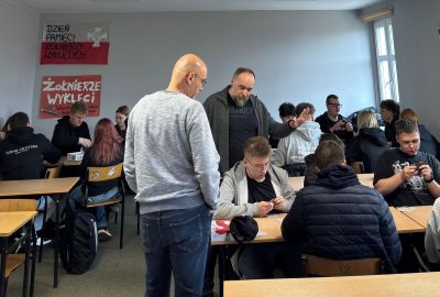 Uczniowie wokół stolika grają w grę planszową.
